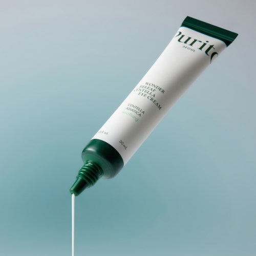 Een tube oogcrème met een kleine hoeveelheid die eruit komt, tegen een gradient achtergrond.
