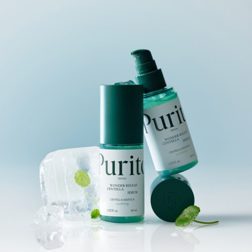 Twee tealkleurige flessen van Purito huidverzorging met ijsblokjes en een klein groen plantblad voor frisheid.