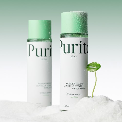 Twee flessen toner met groene doppen en een kleine plant groeit in de sneeuw. De flessen hebben witte labels en zwarte tekst.