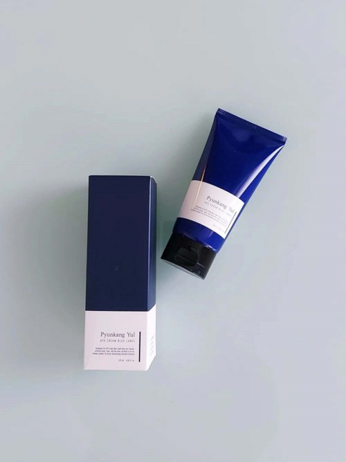 A blue and white tube and box on a plain background, likely skincare or cosmetic product.