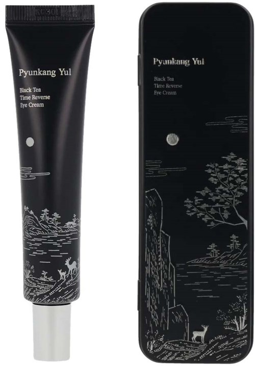 Eine schwarze Tube und ein schwarzes rechteckiges Objekt mit weißem Text und Landschaftsdesign, vermutlich ein Kosmetikprodukt und eine Hülle.