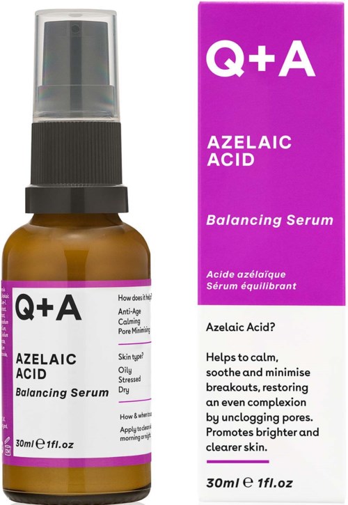 Kleine bernsteinfarbene Flasche mit schwarzem Sprühkopf neben einer lila Schachtel. Etiketten erwähnen Azelainsäure und ausgleichendes Serum.