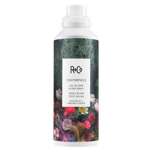 Eine weiße Sprühflasche mit Blumenmuster, beschriftet R+Co Centerpiece All-in-One Elixir Spray.