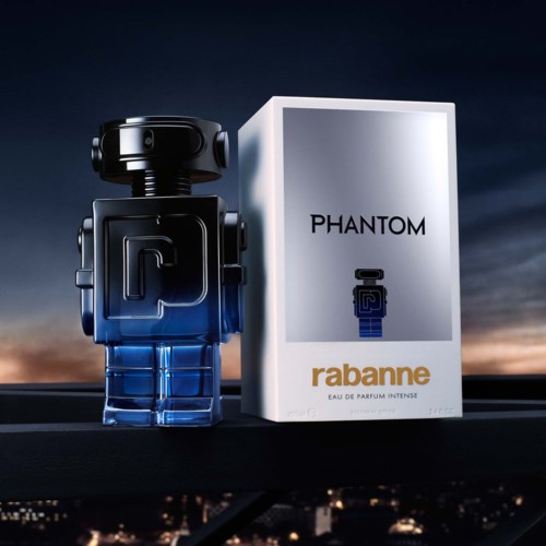 Eine robotförmige Parfümflasche namens Phantom von Rabanne, mit einer Schachtel daneben, vor Sonnenuntergangshimmel.
