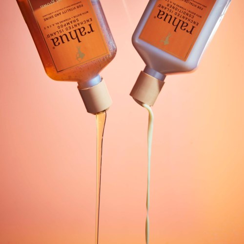 Two shampoo bottles are upside down with liquid pouring out against a pink background.