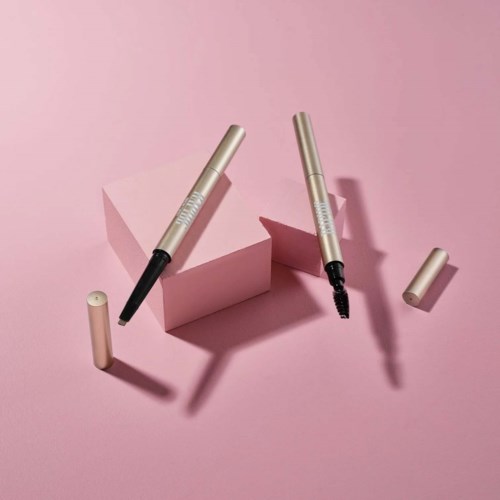 Twee eyeliners, een open met kwast, op roze achtergrond met geometrische vormen.