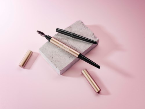 Mascara met zwarte en roze borstels op een roze achtergrond en een grijze blok.