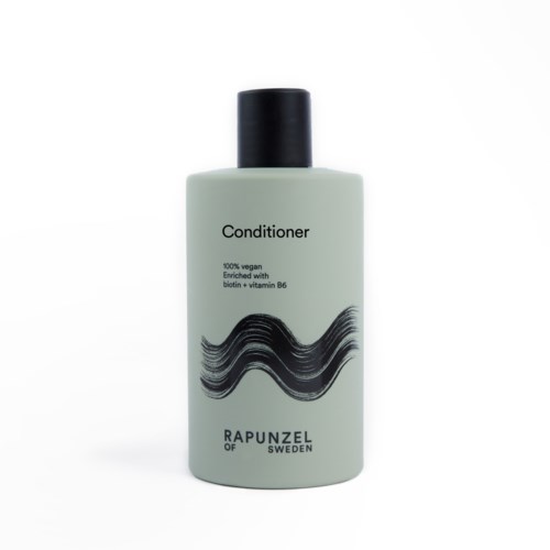 Vaaleanvihreä pullo, jossa lukee 'Conditioner', musta kansi ja musta aaltomainen kuvio.