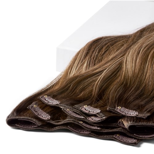 Hair extensions or hair wefts in various shades, neatly arranged on a white surface.
