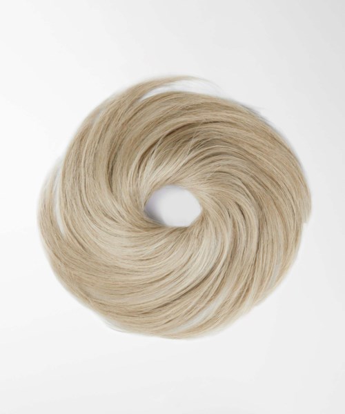 Een blond haarstuk of haarband in een cirkelvorm op een eenvoudige achtergrond.