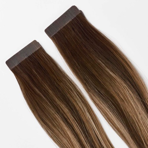 Twee haarverlengingsstrengen met bruin en blond highlights, geplaatst op een witte achtergrond.