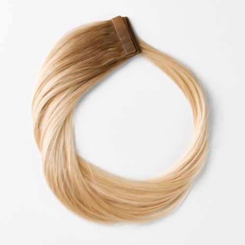 Blont hårförlängning med klämma, formad som en cirkel mot vit bakgrund.