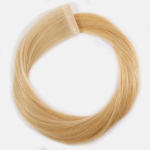 Ett blont hårförlängningsslinga, slät och glänsande, med en plastklämma i ena änden.