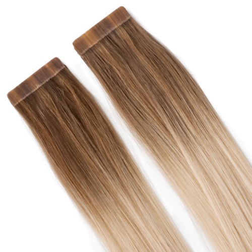 Twee haarextensions met bruin naar blond verloop, recht en glad, naast elkaar gelegd.