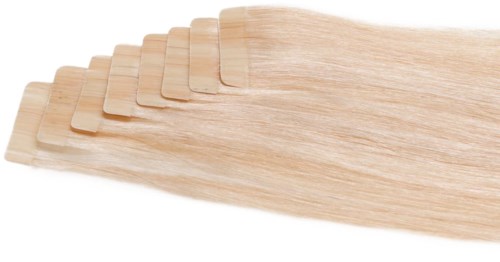Ett set av trähårförlängningar, ljusblont färg, utbrett. De är släta och glansiga.