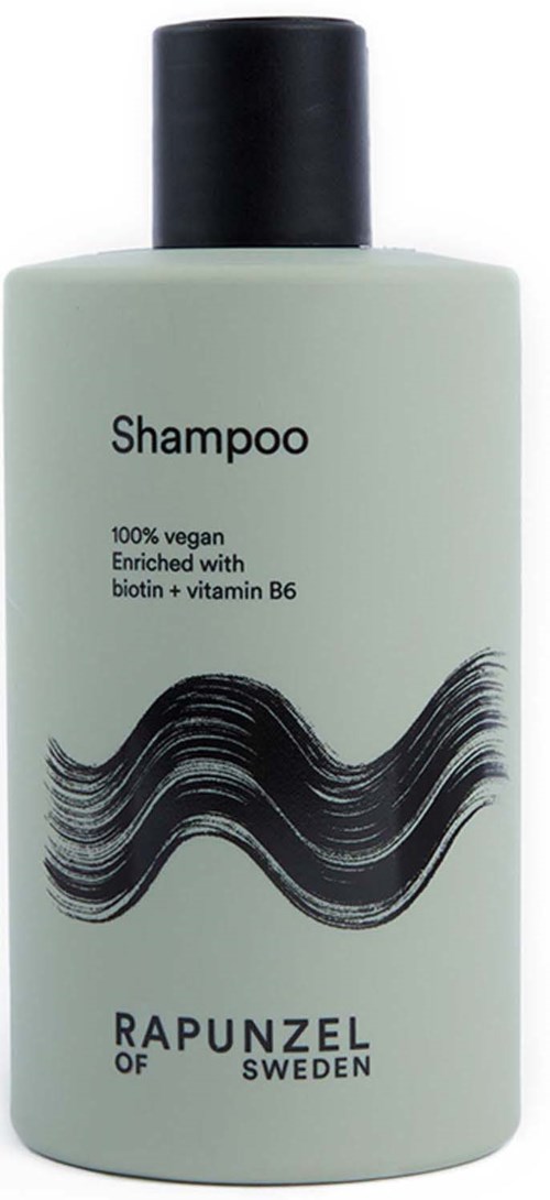 Valkoinen shampoopullo mustalla korkilla, merkitty vegaaniseksi ja rikastettu biotiinilla ja B6-vitamiinilla.