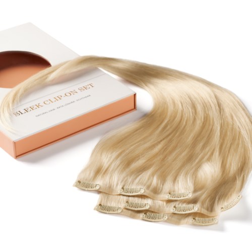 Blonde hair extension clip-in set with a box. The hair appears silky and smooth.