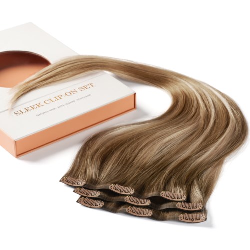 Blonde hair extensions on a white surface with a box labeled "Sleek Clip On Set."