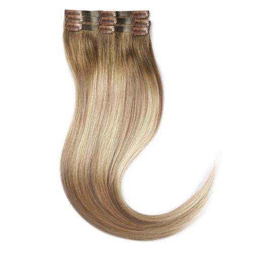 Blonde hair extensions with clips, shiny and straight, arranged in a row.