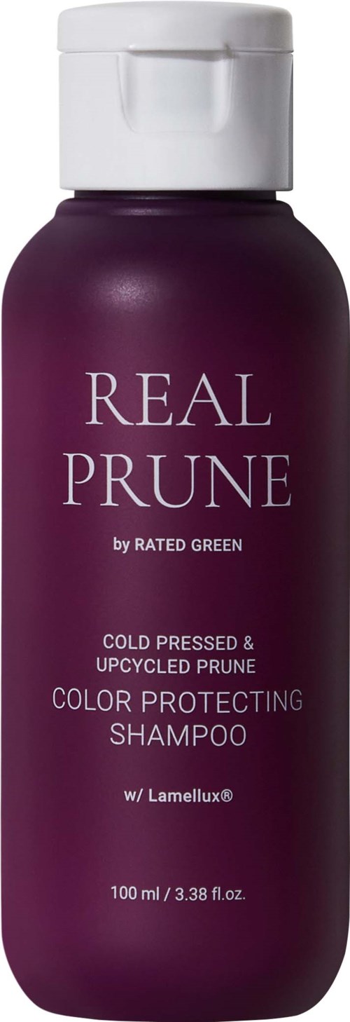 Een donkerpaarse fles shampoo met een witte dop, met label 'Real Prune' en vermeldt kleurbehoud en gerecyclede pruimen.