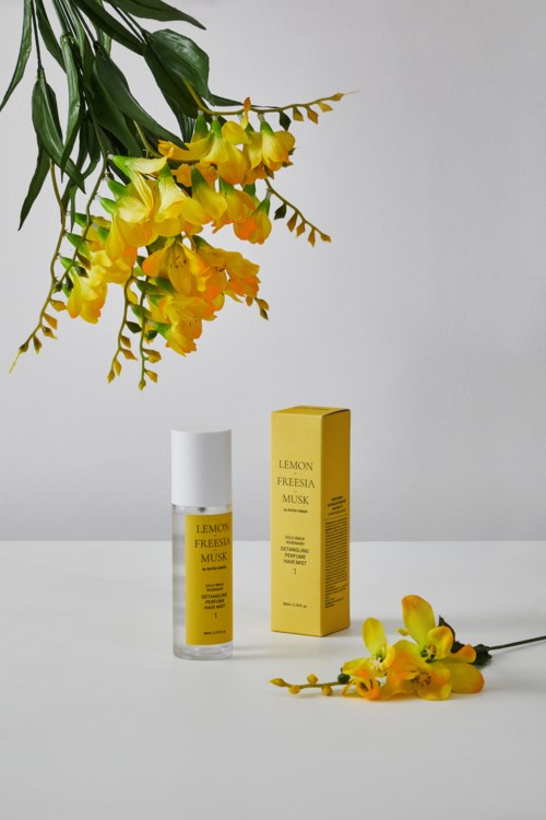 A perfume bottle with yellow flowers and a matching yellow box are displayed against a white background.