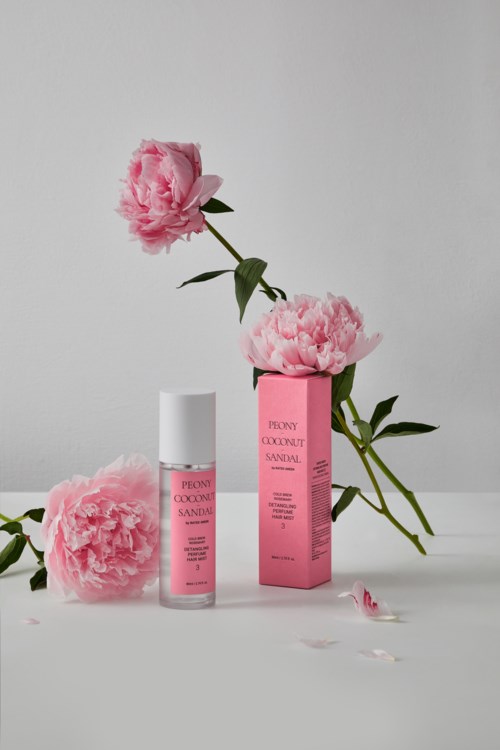 Een huidverzorgingsproduct met roze bloemen en een roze doos, netjes gerangschikt op een effen achtergrond.