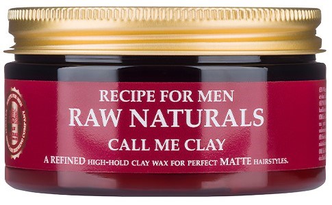 Ein kleiner Behälter mit rotem Etikett, goldener Deckel und weißen Text. Es steht "Recipe for Men Raw Naturals Call Me Clay."