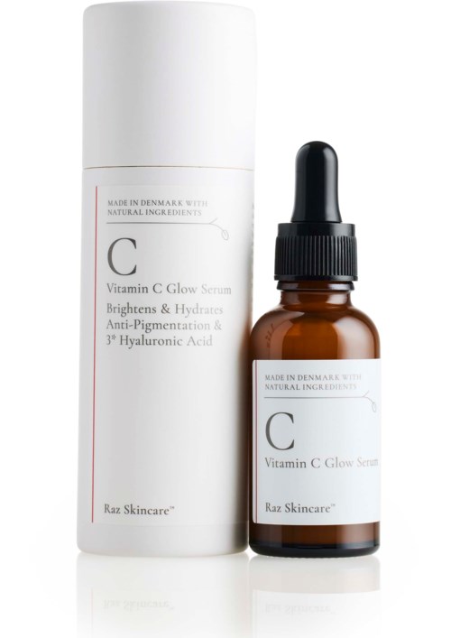 En liten brun flaska med pipett, bredvid en vit cylindrisk behållare, båda märkta 'Vitamin C Glow Serum.'