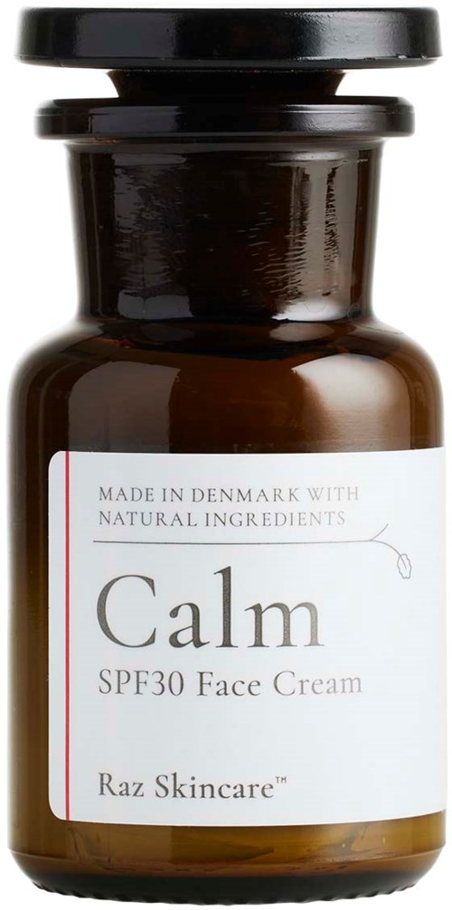 En liten brunt glasflaska med svart lock, märkt 'Calm SPF30 Face Cream' av Raz Skincare, tillverkad i Danmark.