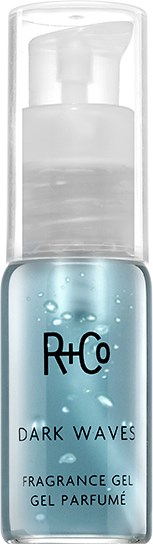 A small, clear bottle with blue gel inside, labeled R+Co Dark Waves fragrance gel, with a pump top.