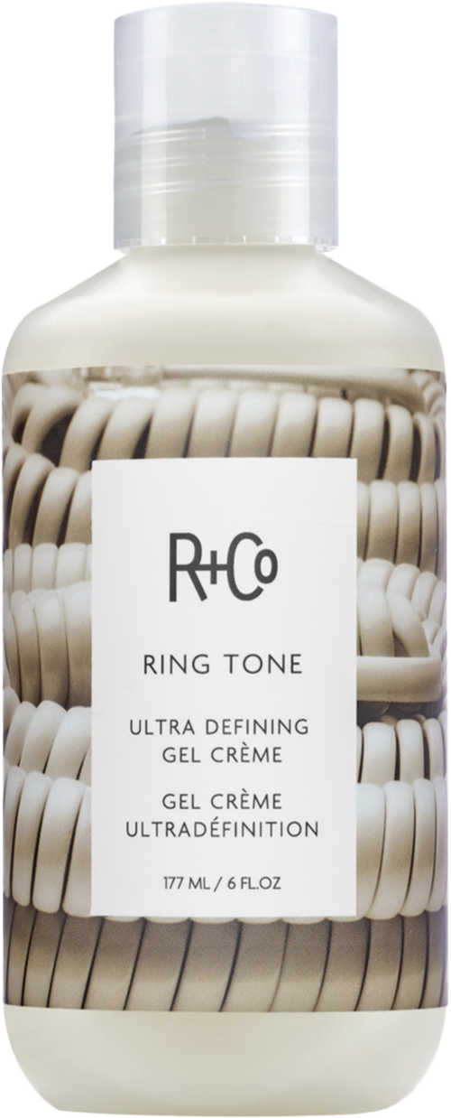 Eine weiße Flasche mit Gel Creme, Etikett zeigt Marke R+Co, steht 'Ring Tone' und 'Ultra Defining.'