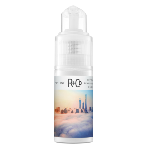 Een klein flesje shampoo met een stadsgezicht en wolken op het etiket.