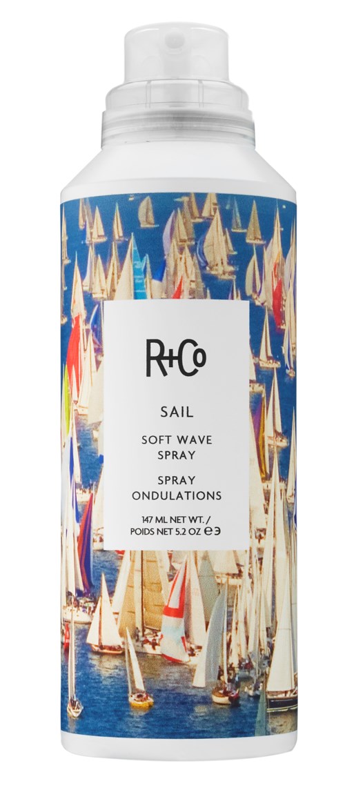 A white spray bottle features a colorful sailboat pattern and the brand name 'R+Co' on the label.