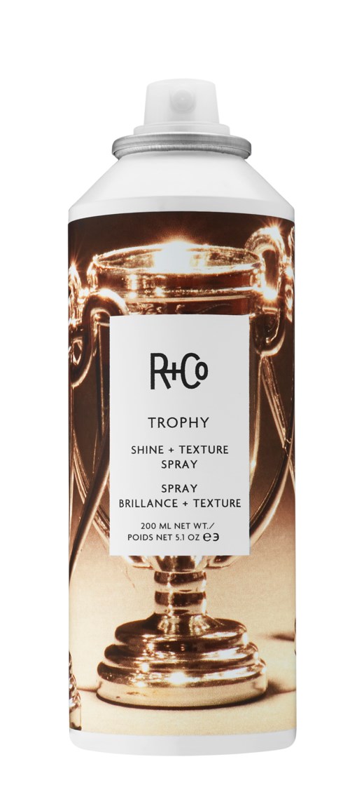 Een spuitfles met een schaker koning en glanzende effecten op het label, genaamd Trophy Shine + Texture Spray.