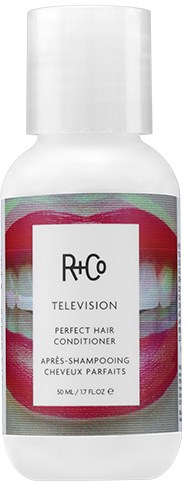En hvit flaske med etikett i rosa, grønt og hvitt. Det er en hårbalsam for TV-styling.