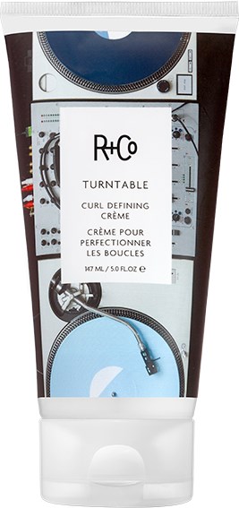 Een tubeverpakking van een haarstylingproduct met een DJ-platensysteem-ontwerp en een wit label in het midden.