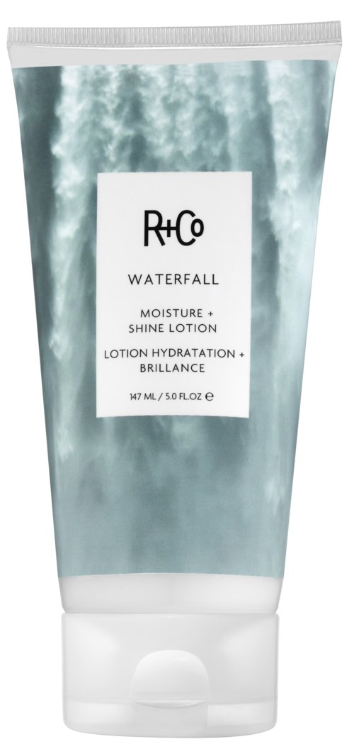 En tube av R+Co Waterfall fuktighetskrem og glanslotion med et blått og hvitt vann-tema design.