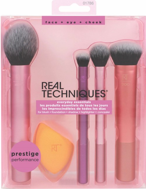 Four makeup brushes and a blending sponge with pink handles in clear pink packaging.