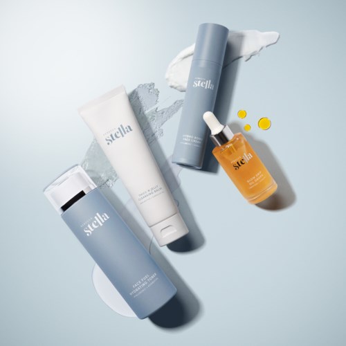 A skincare set with four products, including creams, serum, and drops, all in pastel-colored bottles and tubes.