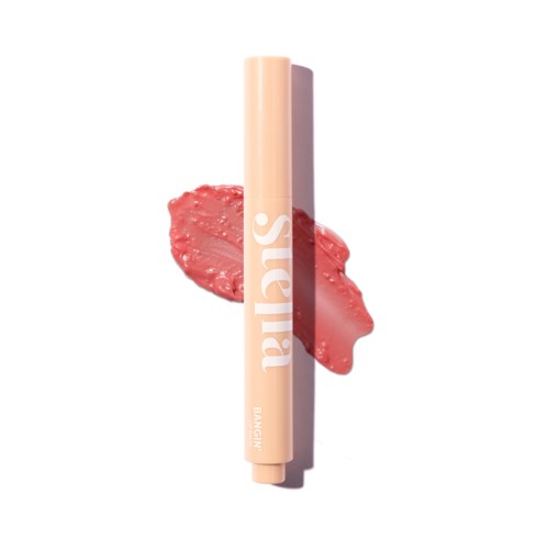 A beige lipstick with white text 'balis' on it, placed vertically. Pinkish smear behind it, on a white background.
