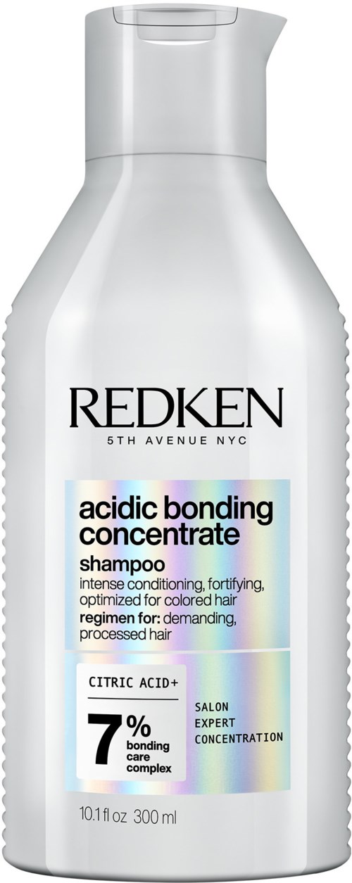 Een wit flesje Redken shampoo met zwarte en blauwe tekst, vermeldt zuurbindingsconcentraat en 7% bindingcomplex.