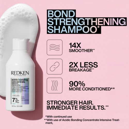 A shampoo bottle with product benefits listed, including smoother hair, less breakage, and more conditioning, on a pink background.
