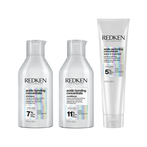 Three bottles of Redken hair care products, two shampoos and one conditioner, with different acid levels.