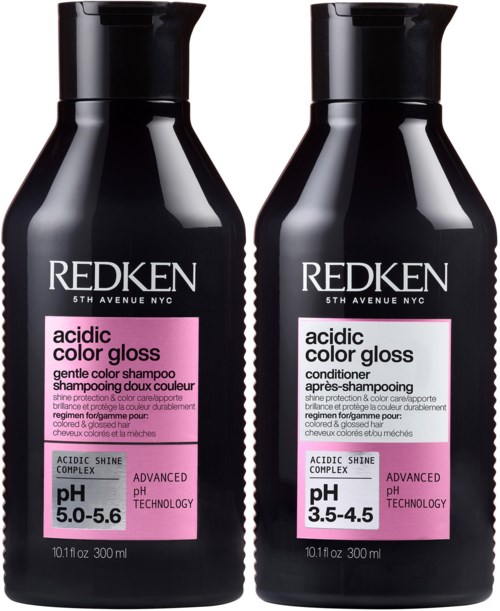 Twee zwarte flessen Redken haarproducten, een conditioner en een shampoo, met roze etiketten met pH-waarden.