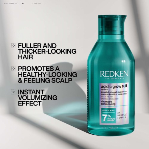 Redken shampoo bottle with text highlighting benefits for hair thickness and scalp health.