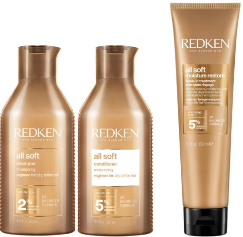 Three hair care bottles from Redken, including shampoo, conditioner, and moisture restore treatment, all in gold-colored packaging.
