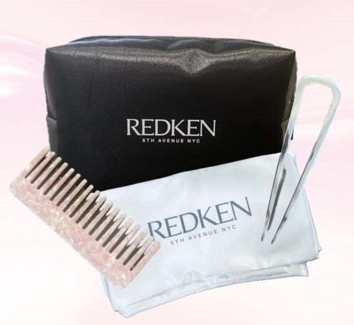 A hair kit with a black bag, a white cloth, a pink comb, and metal hair clips.