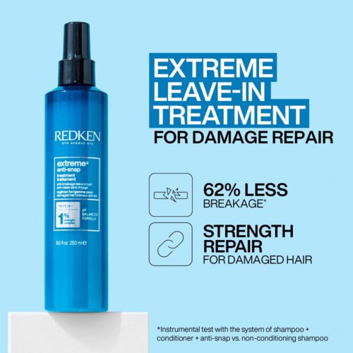 Blauwe fles met Redken leave-in behandeling voor beschadigd haar, beweert 62% minder breuk en versterking.