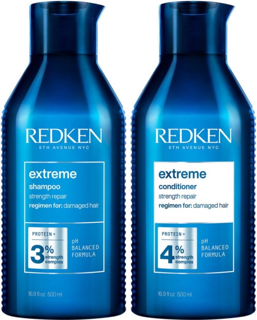 Twee blauwe flessen Redken Extreme haarverzorgingsproducten, één voor shampoo en één voor conditioner, voor beschadigd haar.