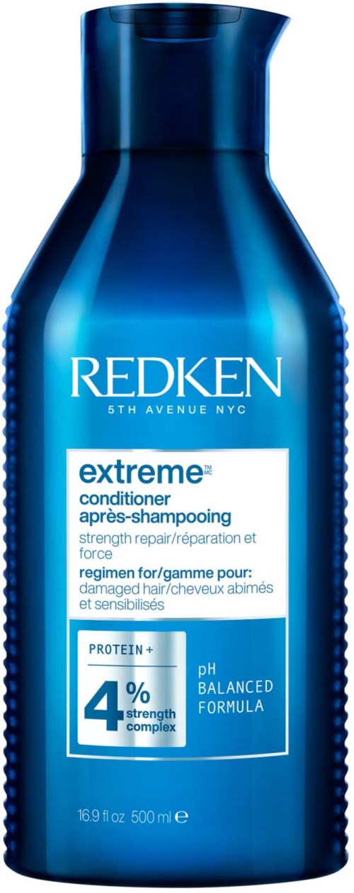 Een blauwe fles Redken Extreme conditioner, voor beschadigd of gevoelig haar, met 4% krachtcomplex en pH gebalanceerde formule.